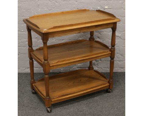 An Ercol Golden Dawn three tier tea trolley on castered legs.