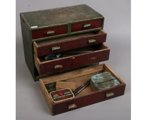 A painted miniature chest of five drawers and contents of engineering tools and vintage advertising tins.Condition report int