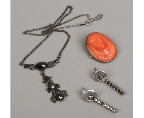 A 19th century carved coral brooch depicting the Madonna, a pair of silver drop earrings and a silver necklet set with garnet