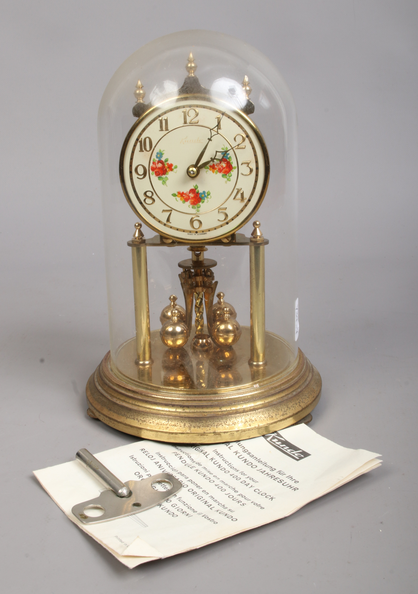 A brass 400 day anniversary clock, maker Kundo, Germany. Under glass