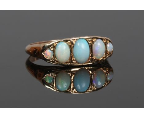 A 9ct gold and five stone opal ring with boat shaped setting and scroll work engraving, size M1/2.