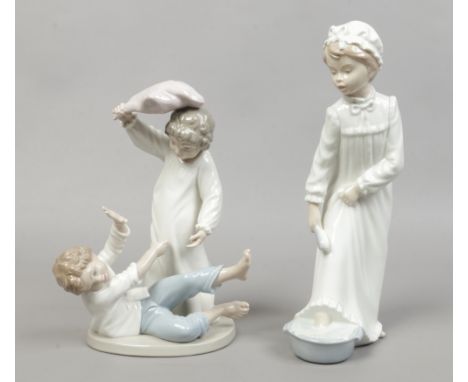 A Nao figure of a young girl washing along with a Nao figure group of two children having a pillow fight (broken thumb).