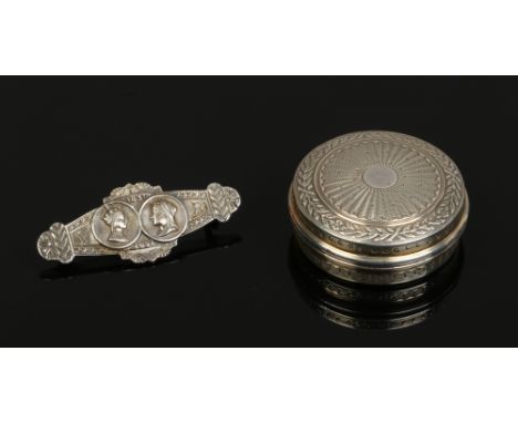 A cased silver commemorative brooch and a French silver pill box with engine turned engraving.