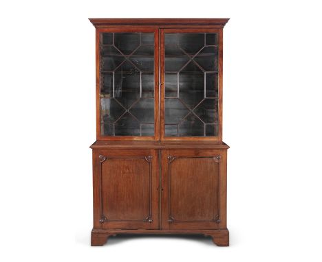 A GEORGE IV MAHOGANY TWO DOOR BOOKCASE, with moulded dentil cornice over twin geometrically glazed doors, with shelved interi