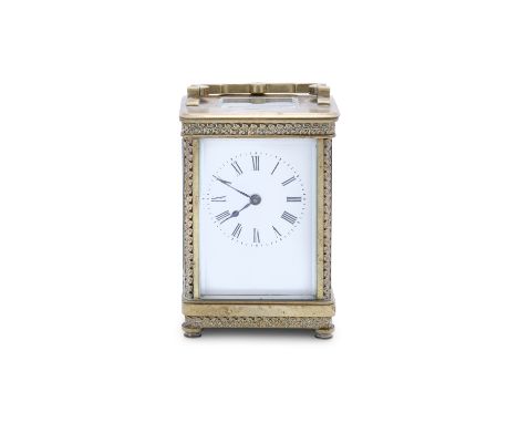 A SMALL BRASS CASED CARRIAGE CLOCK, surmounted by a swing handle, glass panel sides enclosing a white enamel dial, 12cm high 