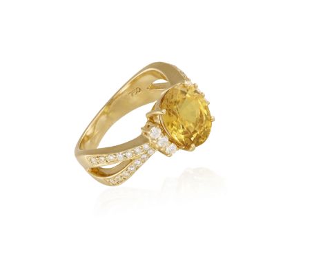 A COLOURED SAPPHIRE AND DIAMOND DRESS RING, the oval mixed-cut yellow sapphire weighing approximately 3.30cts, between round 