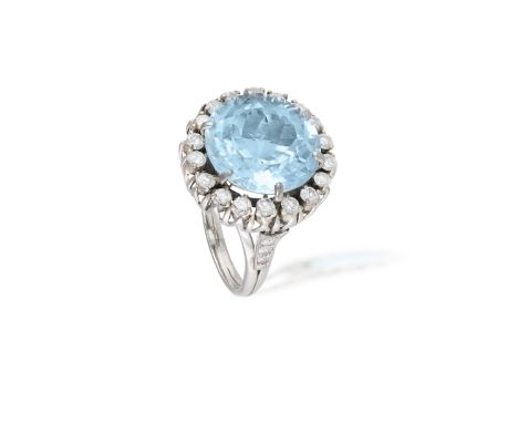 AN AQUAMARINE AND DIAMOND COCKTAIL RING CIRCA 1960, the round mixed-cut aquamarine within a surround of round brilliant-cut d