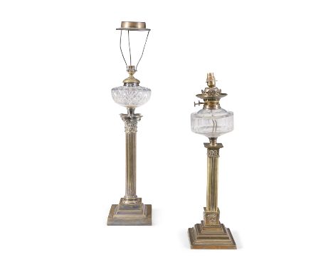 A BRASS COLUMN OIL LAMP, converted to electricity, the clear glass reservoir raised on a square column and stepped base. 55cm
