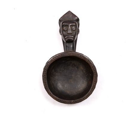 A MAMBELE (CAMEROON) WOODEN LADLE, the handle carved in the form of a face, the circular wooden bowl carved in low relief, 26