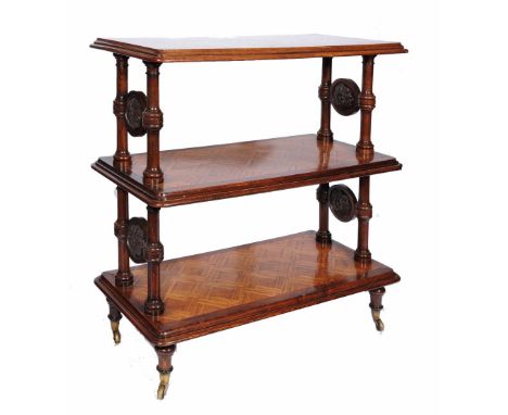 A VICTORIAN HOWARD STYLE OAK GRADUATED THREE TIER BUFFET with geometric parquetry designs, ring turned columns and carved ros