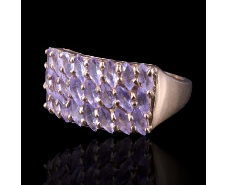 A contemporary purple stone dress ring comprising three rows of marquise-cut stones, obliquely claw-set between the flared sh