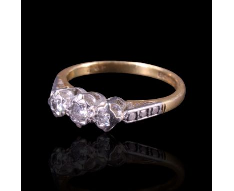 A three-stone diamond dress ring comprising three round-cut stones of approx 0.05 cts aggregate weight, illusion-set between 