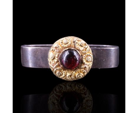 A Victorian almandine cabochon scarf ring, the stone set within a gold flowerhead bezel, mounted on a silver ring, 28 x 12 x 