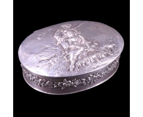 A late 19th / early 20th Century silver pocket snuff or similar box, of oval section, it's hinged lid relief-decorated in dep