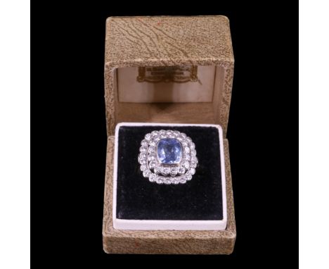A fine sapphire and diamond dress ring comprising a pale blue cushion-cut sapphire of approx 2 ct, bezel-set above terraces o