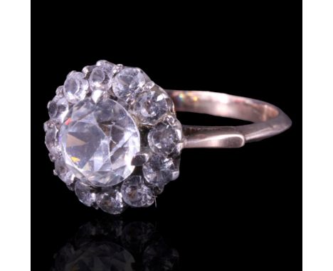 A white-stone cluster ring comprising a central round-cut stone, claw-set between a circular arrangement of smaller stones be