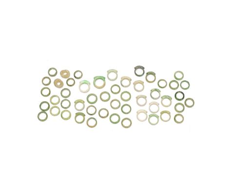 A LARGE COLLECTION OF JADE AND JADEITE RINGSEarly 20th centuryComprising: seventeen saddle rings, thirty abacus seed rings an
