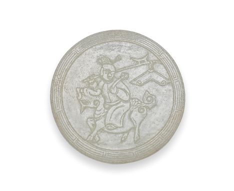 A JADE CIRCULAR PLAQUE18th/19th centuryCarved to depict a boy riding a qilin within a key scroll border the rim, the reserve 