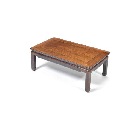 A HUANGHUALI LOW TABLE, KANG19th centuryThe top panel set within a standard mitre frame, over a short recessed waist, set abo
