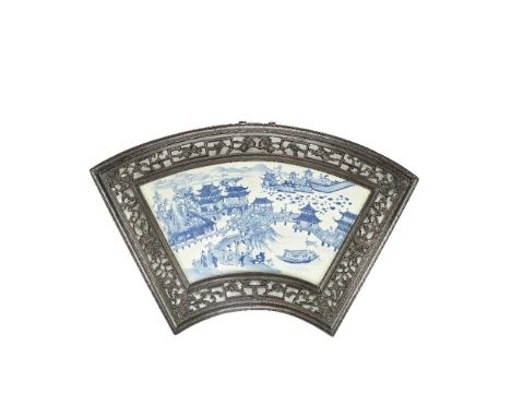 A BLUE AND WHITE FAN-SHAPED PORCELAIN PLAQUE20th centuryPainted with a river landscape with buildings connected by a series o