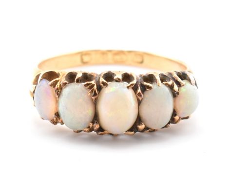 A Victorian hallmarked 18ct gold and opal five stone gypsy ring. The ring set with five graduating opal cabochons set in a pi