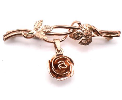 A hallmarked 9ct rose gold flower brooch pin. The 9ct rose gold brooch pin having leaves twisting across the bar brooch with 