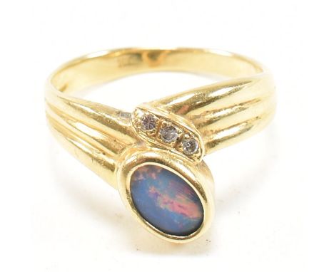 An 18ct gold, diamond and opal ring. The ring having a central bezel set opal flanked by three round cut diamonds. Marked 18K