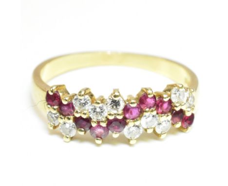 A hallmarked 18ct gold ruby and diamond half hoop ring. The 18ct yellow gold ring set with a central meandering row of ten ro