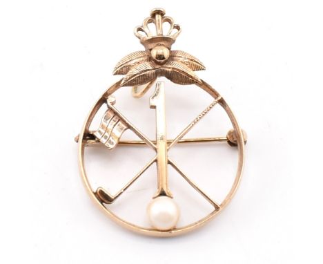 A hallmarked 9ct gold and cultured pearl golfing brooch pin. The 9ct yellow gold circular brooch pin having a golf club cross