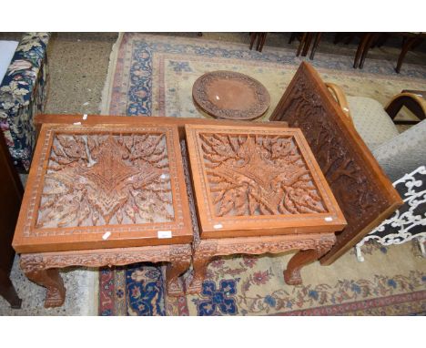A suite of Far Eastern carved hardwood items comprising a pair of square topped lamp tables, a pair of wall plaques and a sma