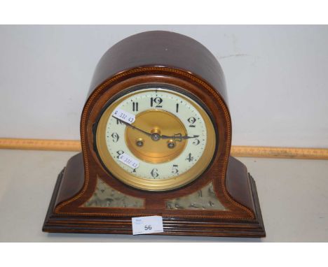 An early 20th Century mantel clock set in an arched inlaid case