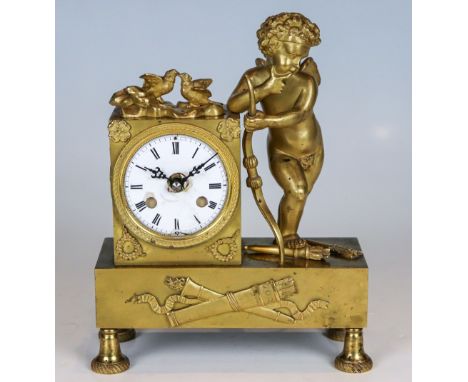 Kleine Empire-Uhr mit Amor  Frankreich, um 1820 Bronze, vergoldet. Auf vier Glockenfüßen ein Rechtecksockel mit asymmetrisch 