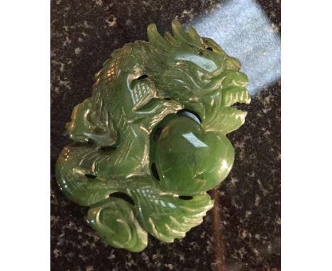 A carved Jade pendant of a coiled Dragon with a heart motif