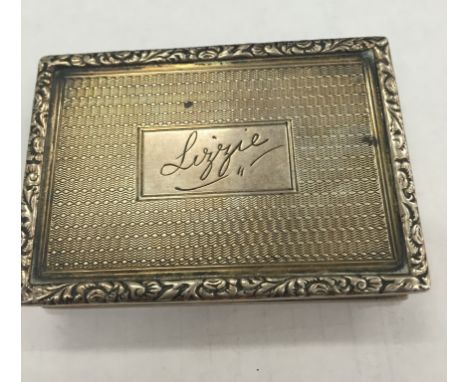 A large Edwardian silver snuff box with raised floral borders and engine-turned design: waisted centre, engraved "Lizzie" to 