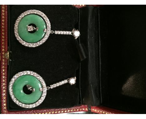 A boxed pair of jade and diamond earrings, jade pi disc surrounded by an annulet of diamonds on articulated drop on post fixi