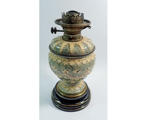 A late 19th century Doulton Lambeth oil lamp, the green mottled glaze moulded in relief with floral swags and swallows, Hink'