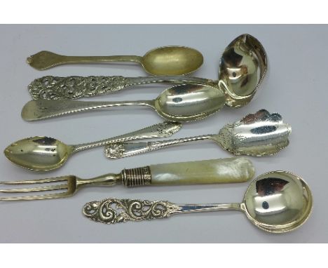 A Norwegian silver ladle by Martinsen, a silver and mother of pearl fork, a silver caddy spoon and four other silver spoons, 