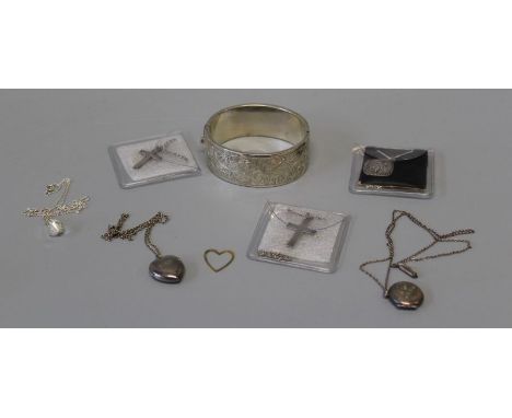 A selection of 20th century silver and white metal featuring a 34.9gm hinged bangle, three pendants, two lockets and an auror