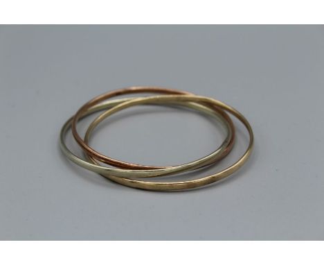 A 9ct gold "Russian wedding ring" style bangle comprising three interlinked bangles of white, rose and yellow gold. Gross wei