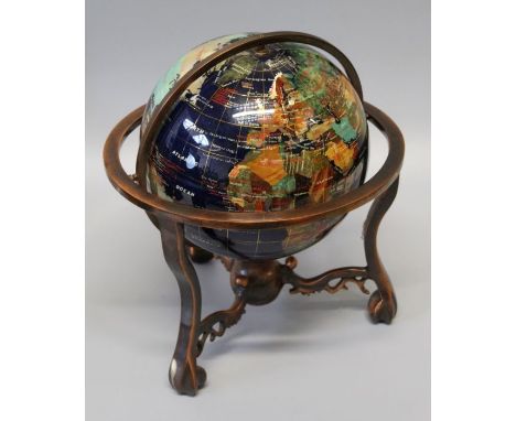 An eight inch terrestrial globe, set with veneers of semi-precious stones, in a bronzed metal cradle mount