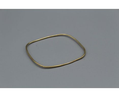 A yellow metal square shaped fine bangle. Unmarked. Approximate weight 5.3 grams. Tests on the surface in the region for 14kt