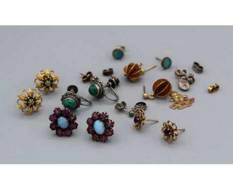 A collection of earrings in 9ct gold, yellow and white metals. To include a pair of 9ct green and white stone set flower stud