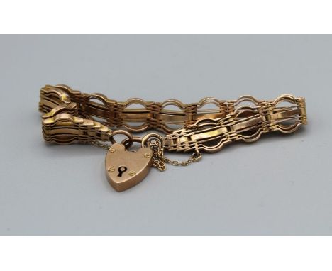 A yellow metal gate bracelet with a heart padlock clasp, stamped "9ct", plus a safety chain. Total approximate weight 19.6 gr