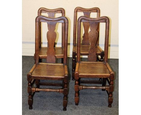 A set of four early 18th century provincial elm dining chairs, each having bowed rail, vase splat, solid panel seat, on pegge