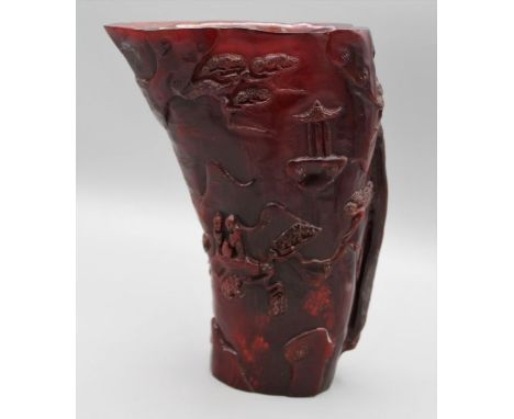 A Chinese carved horn libation cup, decorated with figures, pagodas and trees. 21.5cm