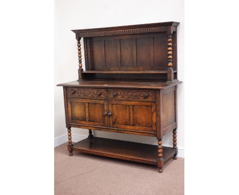 Early 20th century oak sideboard fitted with two drawers and two cupboards with raised panelled back, bobbin turned supports,