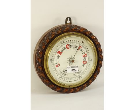 Early 20th century aneroid barometer mounted on oak with rope twist moulding, D23cm CLOCKS & BAROMETERS - as we are not a ret