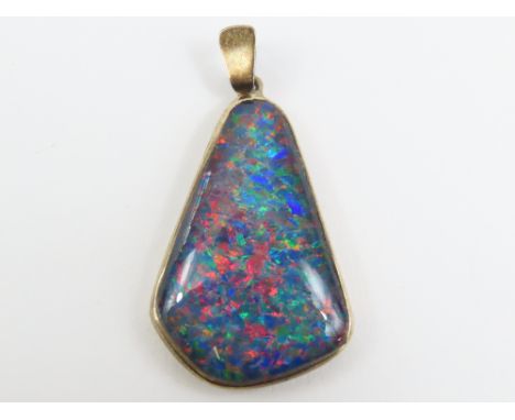 A free form black opal doublet pendant, the opal displays a harlequin pattern, approximately 4.3cm long including bale, in si