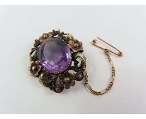An early to mid 20th century brooch, set with a central oval facetted amethyst, in a two colour foliate surround, 3cm x 2.5cm