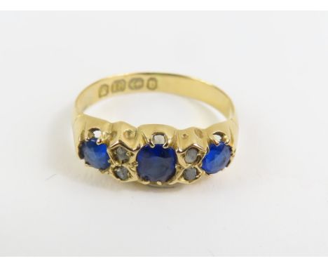 A Victorian 18ct gold blue paste and diamond ring, the three sapphires with diamond accents between, finger size K 1/2, 2g gr